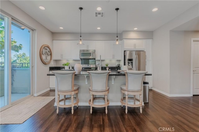 kitchen with white cabinetry, a center island, dark wood-type flooring, and appliances with stainless steel finishes