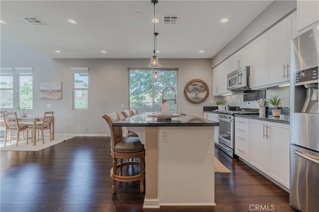 kitchen featuring white cabinetry, a center island, stainless steel appliances, and dark hardwood / wood-style floors