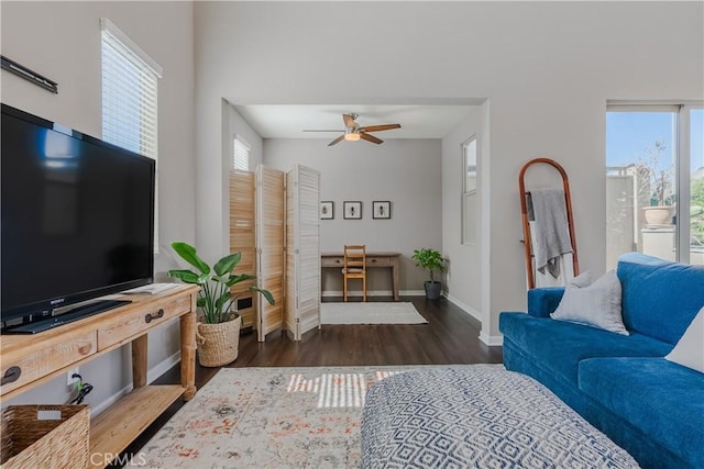 living room featuring ceiling fan and dark wood-type flooring