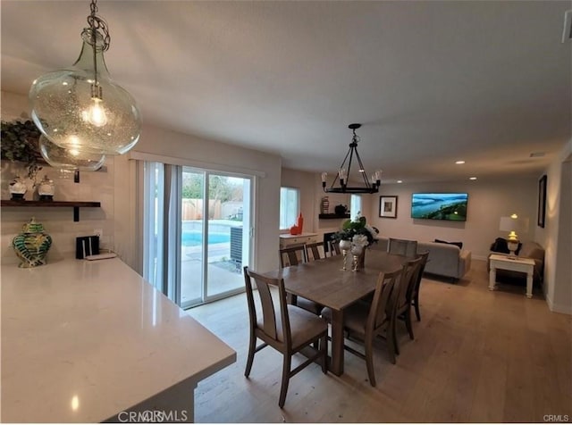 dining area featuring light wood-type flooring and a chandelier