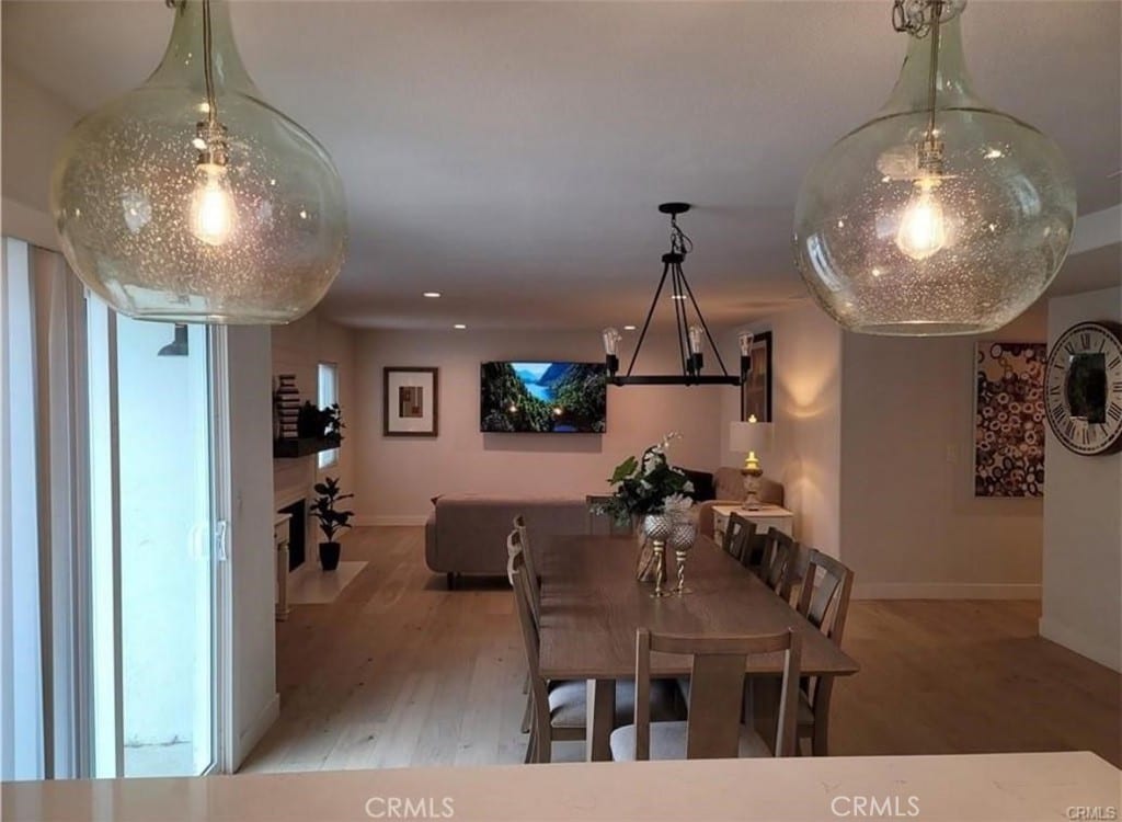 dining space with a notable chandelier and light hardwood / wood-style flooring