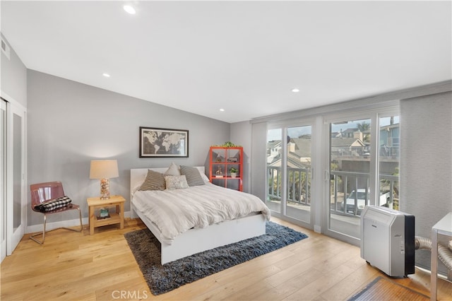 bedroom with light hardwood / wood-style flooring, vaulted ceiling, and access to outside