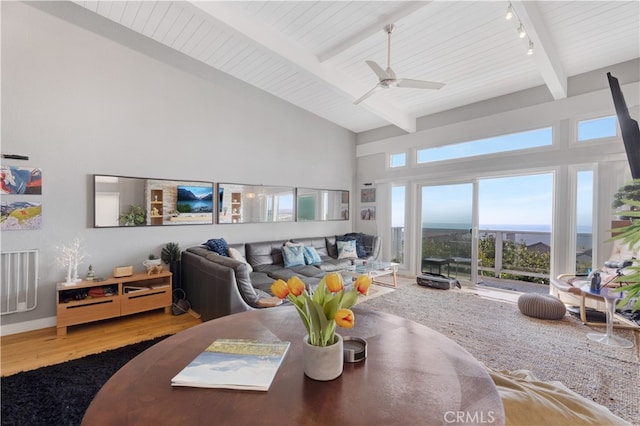 living room featuring ceiling fan, beamed ceiling, high vaulted ceiling, rail lighting, and hardwood / wood-style flooring