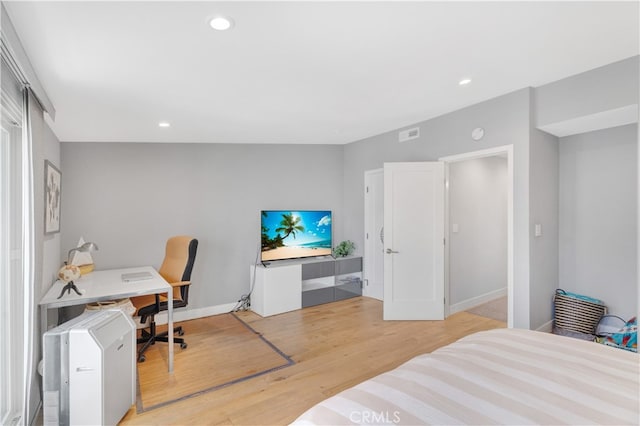 bedroom with light hardwood / wood-style floors and a closet