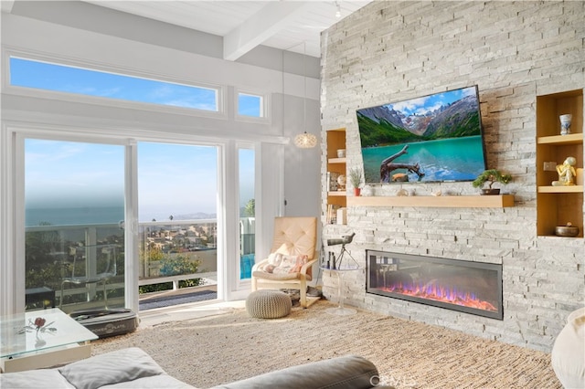 living room with beamed ceiling and a stone fireplace