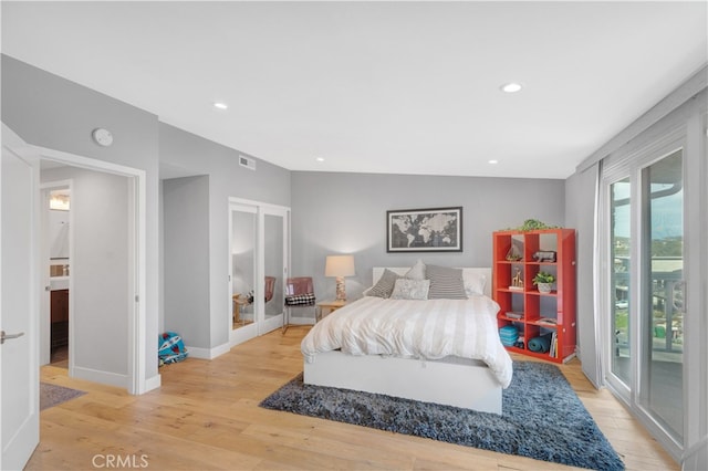 bedroom featuring vaulted ceiling, light wood-type flooring, and access to exterior