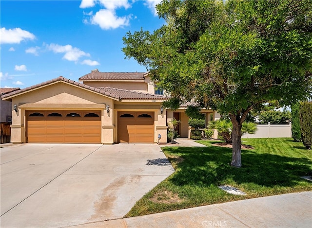 mediterranean / spanish house with a garage and a front yard