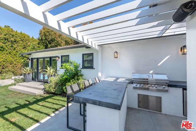 view of patio featuring a pergola, area for grilling, and an outdoor kitchen