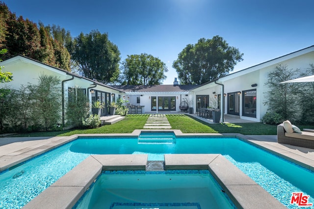 view of pool with a patio, an in ground hot tub, and a yard