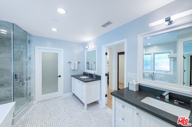 bathroom featuring tile patterned floors, an enclosed shower, and vanity