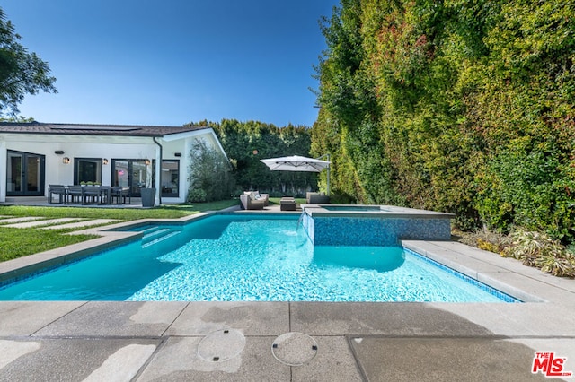 view of swimming pool featuring an in ground hot tub and a patio area