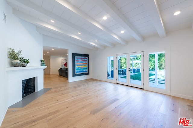 unfurnished living room with light wood-type flooring and vaulted ceiling with beams