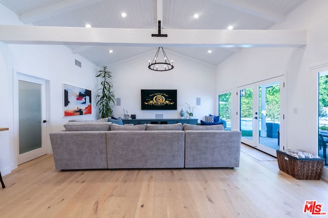 living room with high vaulted ceiling, beamed ceiling, an inviting chandelier, light hardwood / wood-style flooring, and french doors