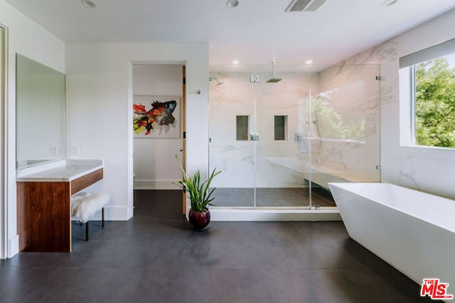 bathroom with concrete flooring, vanity, and separate shower and tub