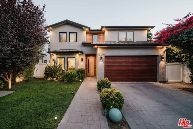 view of front of property with a yard and a garage