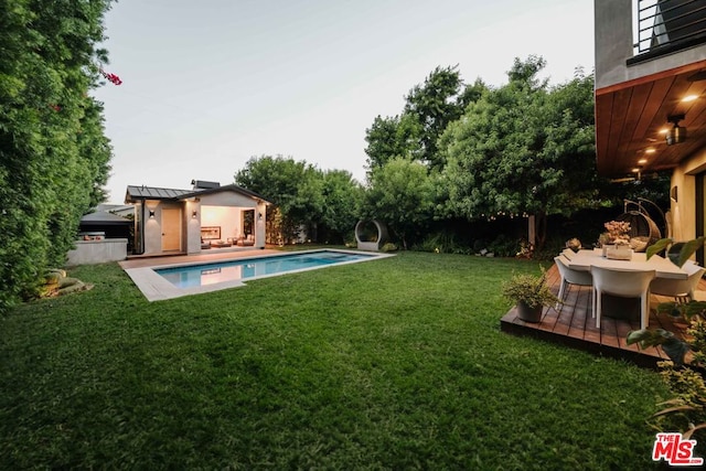 view of swimming pool with a yard and an outdoor structure