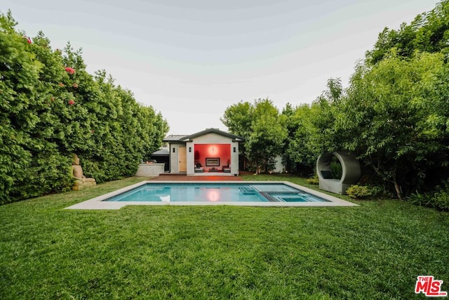 view of pool featuring an outdoor structure and a lawn