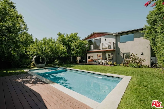 view of swimming pool featuring a lawn and an in ground hot tub