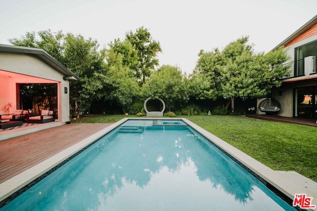 view of pool featuring a lawn and a wooden deck