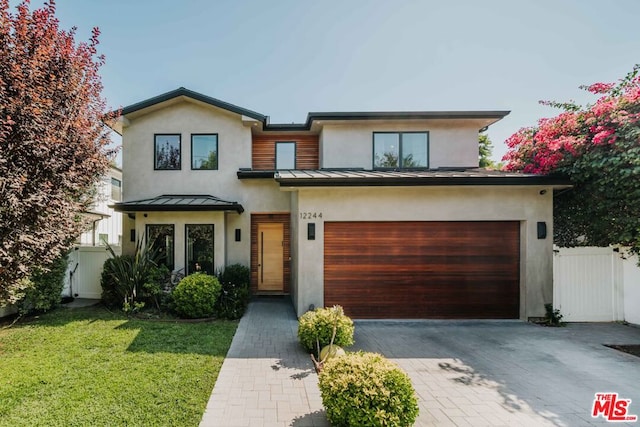 contemporary house featuring a garage and a front lawn