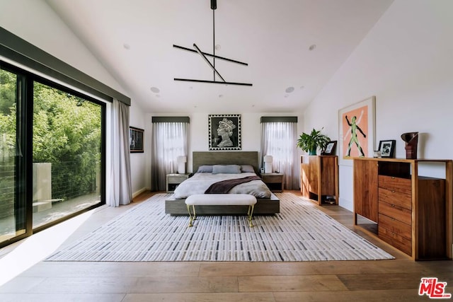 bedroom with high vaulted ceiling and light hardwood / wood-style floors