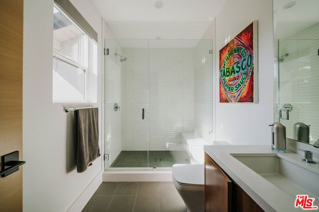 bathroom with tile patterned floors, a shower with door, vanity, and toilet