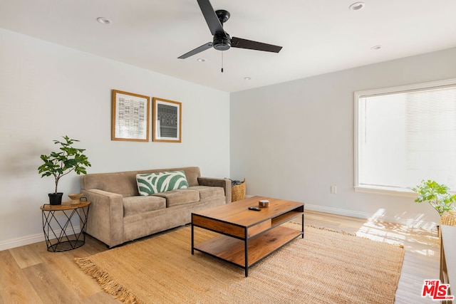 living room with light hardwood / wood-style flooring and ceiling fan