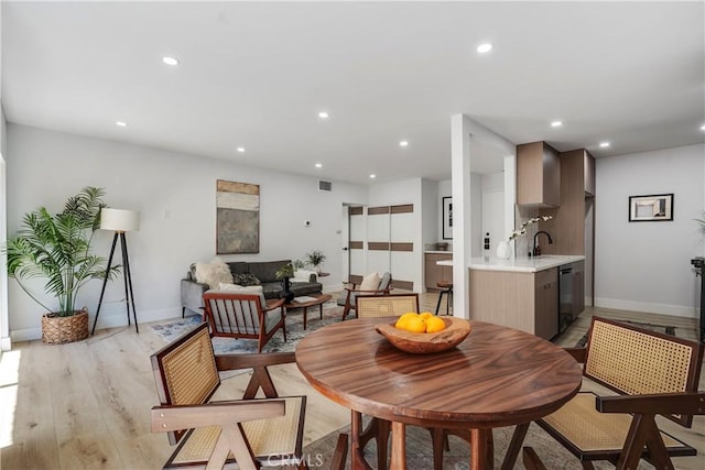 dining area with light hardwood / wood-style flooring and sink