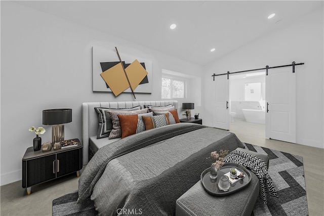 bedroom featuring vaulted ceiling, ensuite bathroom, and a barn door