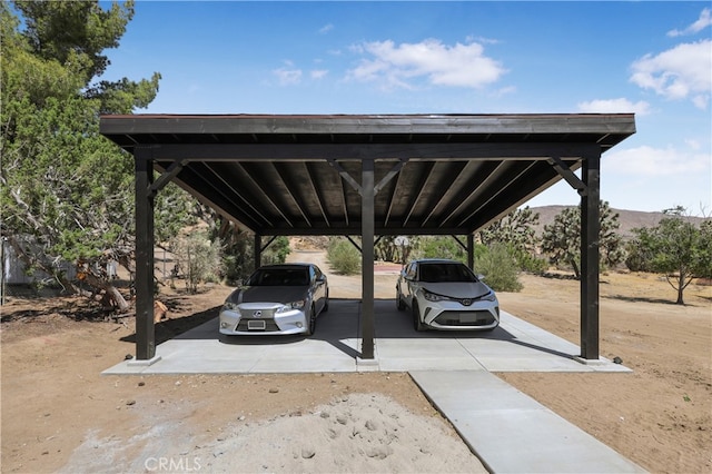 view of parking with a mountain view and a carport