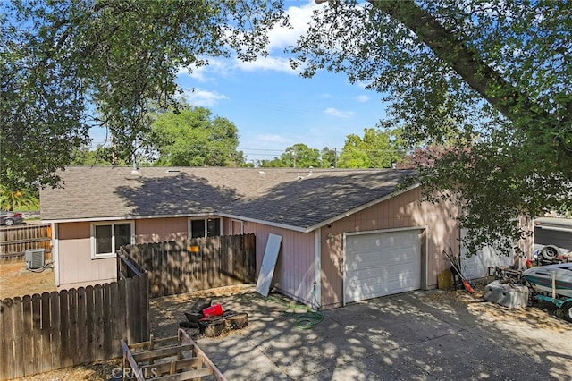 single story home featuring central AC unit and a garage