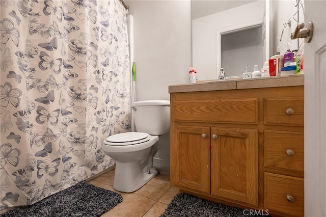 bathroom featuring walk in shower, vanity, toilet, and tile patterned floors