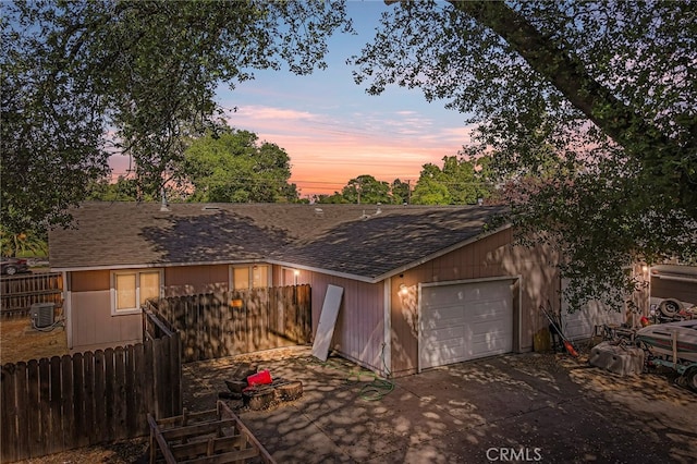 garage at dusk featuring wood walls and central air condition unit