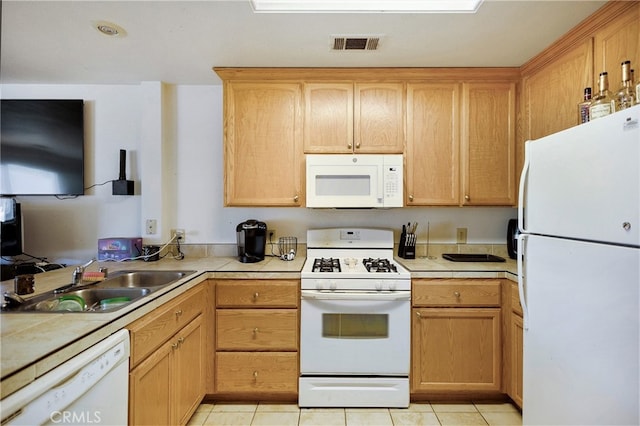 kitchen with light tile patterned floors, sink, white appliances, tile countertops, and light brown cabinetry