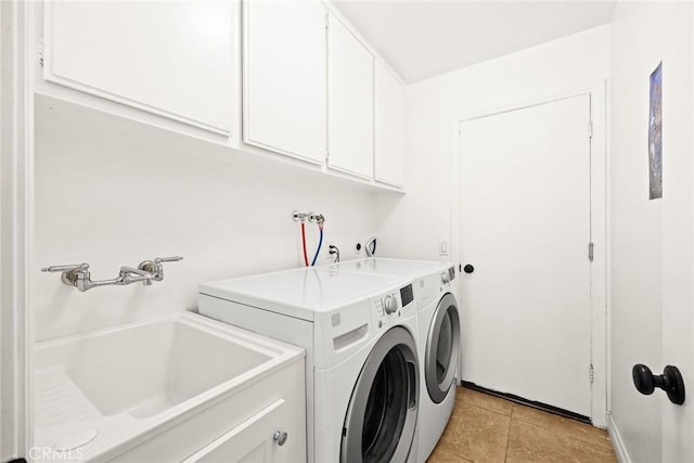 washroom with sink, light tile patterned floors, cabinets, and independent washer and dryer