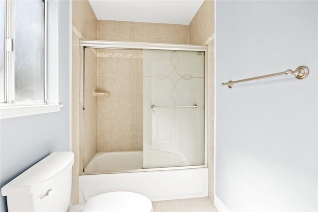 bathroom with combined bath / shower with glass door and toilet