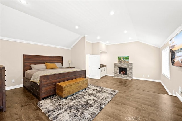 bedroom featuring hardwood / wood-style floors, a fireplace, crown molding, and vaulted ceiling