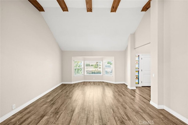 unfurnished living room featuring beam ceiling, hardwood / wood-style flooring, and high vaulted ceiling