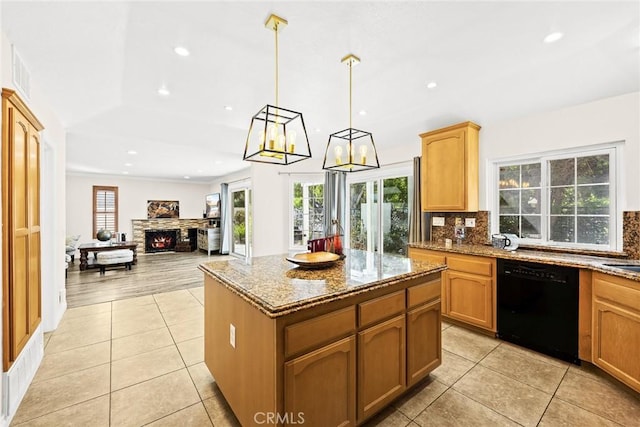 kitchen featuring light stone countertops, a fireplace, pendant lighting, dishwasher, and a kitchen island