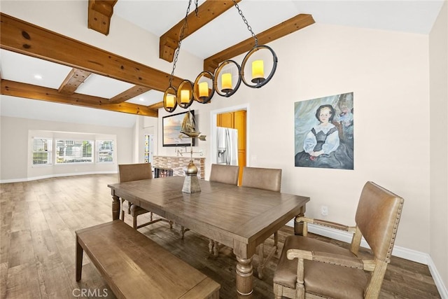 dining area featuring vaulted ceiling with beams and wood-type flooring