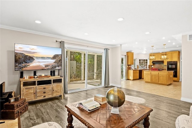 living room featuring light hardwood / wood-style flooring and crown molding