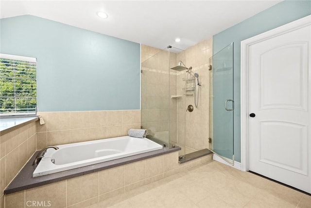 bathroom with tile patterned flooring, separate shower and tub, and vaulted ceiling