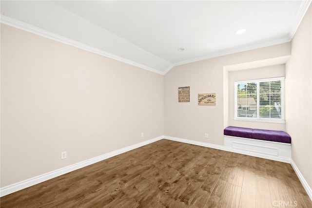 unfurnished room featuring lofted ceiling, wood-type flooring, and ornamental molding