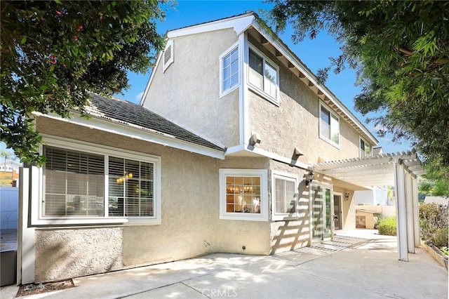 back of property with a pergola and a patio area