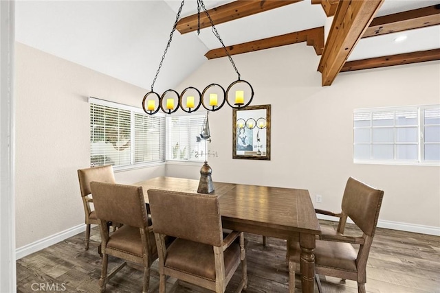 dining space featuring wood-type flooring, vaulted ceiling with beams, and an inviting chandelier