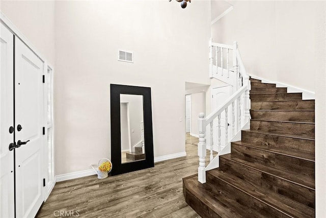 entryway featuring hardwood / wood-style floors and a towering ceiling