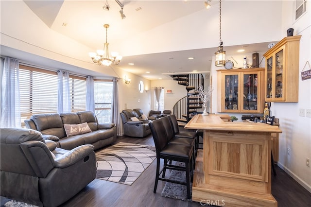 living room featuring an inviting chandelier, vaulted ceiling, and dark hardwood / wood-style flooring