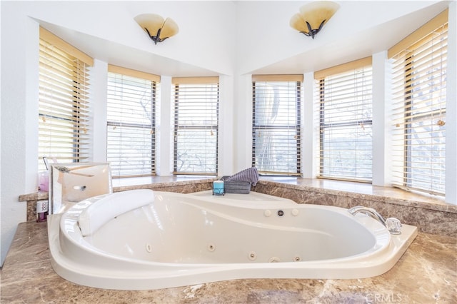 bathroom featuring tiled tub and plenty of natural light