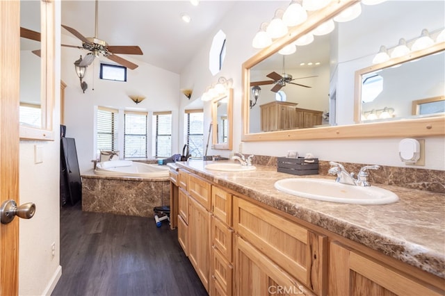 bathroom featuring vanity, tiled bath, hardwood / wood-style floors, and high vaulted ceiling