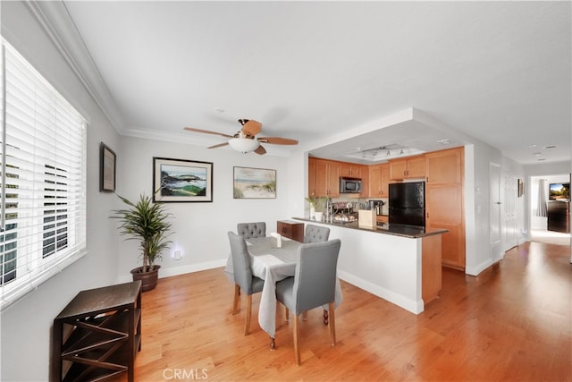 dining room with ceiling fan, light wood-type flooring, and ornamental molding